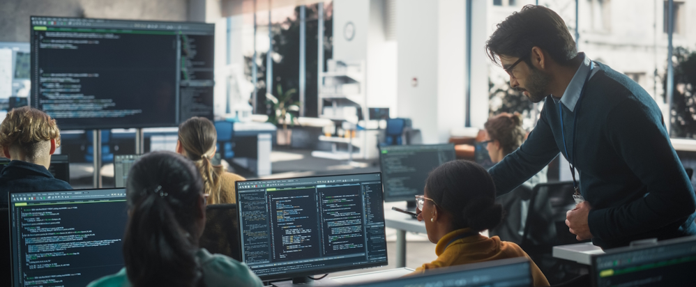 Professor reviewing students' programming projects and offering feedback